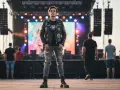 Chłopak w ramonesce z naszywkami i podartych jeansach, idealny przykład, jak się ubrać na koncert metalowy.