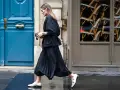 Elegancka stylizacja: czarna, plisowana spódnica i marynarka. Idealna inspiracja, co założyć do plisowanej spódnicy, by wyglądać szykownie.