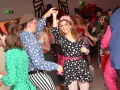 Impreza w stylu PRL! Kobieta w grochy i mężczyzna w paski tańczą. Idealny strój na imprezę w stylu PRL to kolorowe wzory i dodatki.