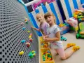 Dwie dziewczynki bawią się w sali zabaw. Idealny strój na urodziny do sali zabaw to wygodne ubranie i kolorowe skarpetki.