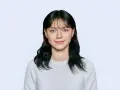 Dziewczyna w białym swetrze, idealna stylizacja, jak trzeba być ubranym do zdjęcia do dowodu.