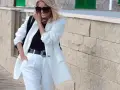 Elegancka stylizacja na roczek: biały garnitur, czarna bluzka i ozdobny pasek. Idealna inspiracja, jak się ubrać na roczek!
