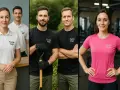 Uśmiechnięci pracownicy w koszulkach z logo firmy. Białe polo, czarne t-shirty z łopatą i różowa koszulka sportowa.