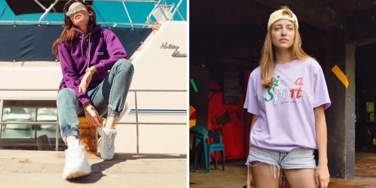 Dwie kobiety w modnych stylizacjach streetwear. Jedna w fioletowej bluzie i jeansach, druga w liliowej koszulce z napisem "Pizza Sport". Polskie marki odzieżowe streetwear w akcji.