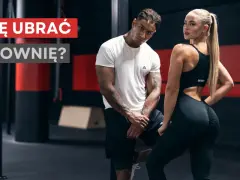 Jaki strój na siłownię? Para w sportowych ubraniach pozuje na tle siłowni.