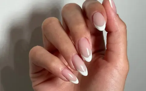 Dłonie z klasycznym french manicure. Czy french jest jeszcze modny? Zdecydowanie tak, wygląda elegancko i ponadczasowo.