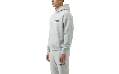 Szary komplet Essentials z kapturem i spodniami dresowymi. Zastanawiasz się, ile waży bluza Essentials? Jest lekka i wygodna.