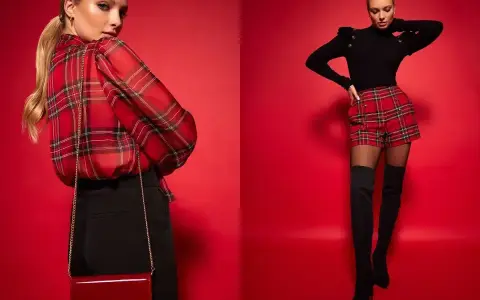 Modelka w czerwonym, kraciastym kiltcie i czarnym sweterku. Obok druga modelka w kraciastej bluzce i czarnych spodniach.
